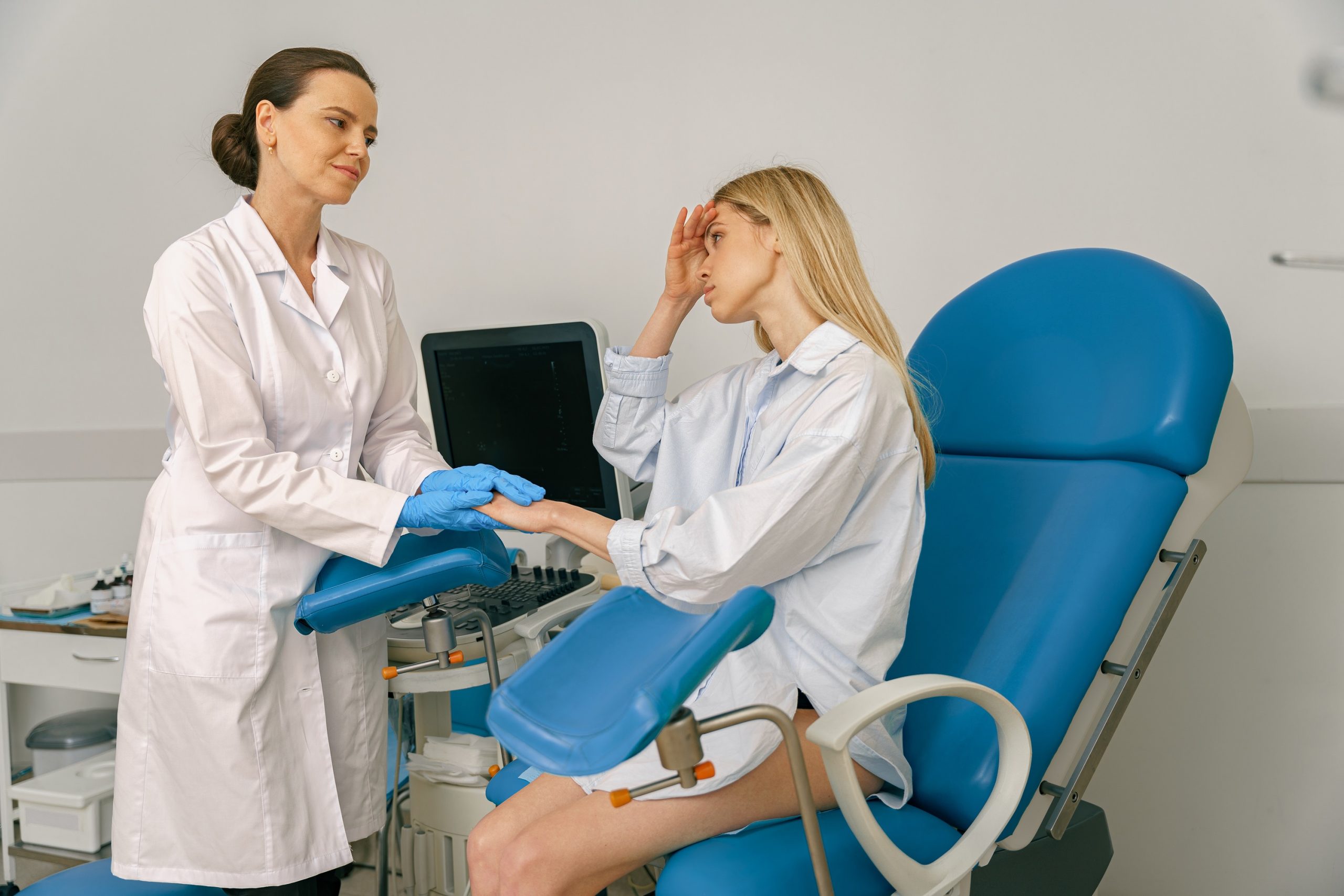 Sad woman is talking and shaking hands with a gynecologist in woman consultation during appointment